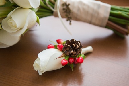 white roses groomsmen boutonniere and wooden backgroundの写真素材
