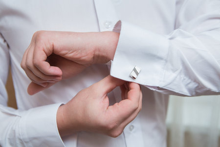 close up of a hand man how wears white shirt and cufflink
