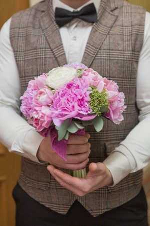 big nice wedding bouquet in groom handの写真素材