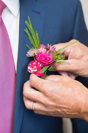 Boutonniere on hip trendy groom at weddingの写真素材