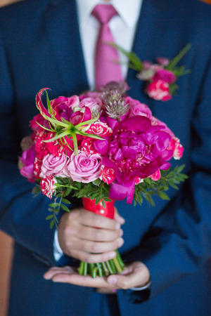 big nice wedding bouquet in groom handの写真素材