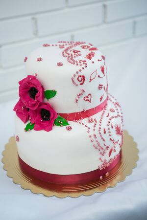 white multi level wedding cake with pink flower decorationsの写真素材