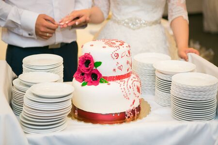 white multi level wedding cake with pink flower decorationsの写真素材