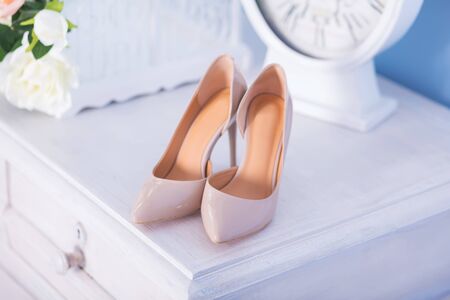 Elegant and stylish bridal beige shoes on chest of drawersの写真素材