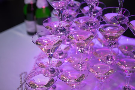 martini glasses in the form of a cascade or pyramid lit light at the wedding partyの写真素材