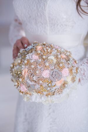 Beautiful wedding bouquet of different flowers in the hands of the brideの写真素材