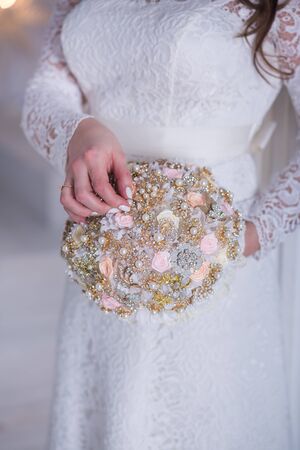 Beautiful wedding bouquet of different flowers in the hands of the brideの写真素材