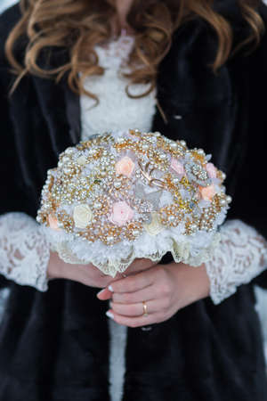 Beautiful wedding bouquet of different flowers in the hands of the brideの写真素材