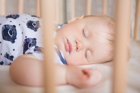 Peaceful adorable baby sleeping on his bed in a room. Soft focus. Sleeping baby concept. year-old babyboy sleeps at home close upの写真素材