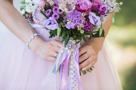 Beautiful wedding colorful bouquet with different flowers in the hands of the bride. Bridal summer bouquetの写真素材