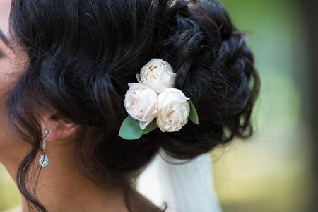 Black wedding hair styling. Brunette bride with curly hairstyle with barrette. Wedding conceptの写真素材