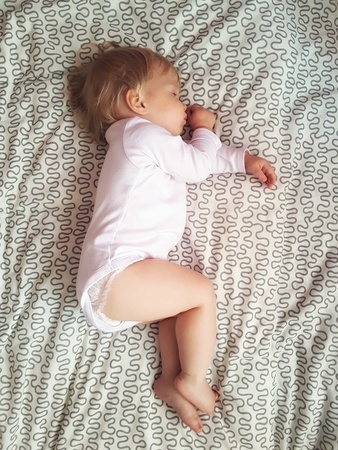 Year-old baby sleeping on the bed. Little baby boy sleep at home. Child is sleepingの写真素材