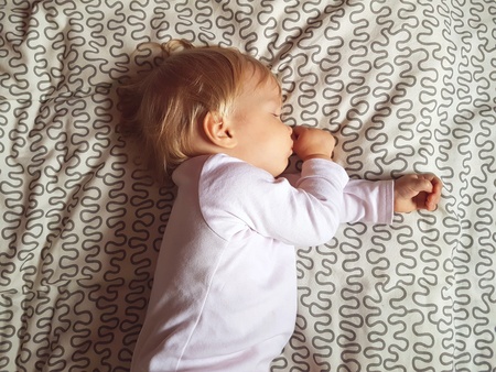 Year-old baby sleeping on the bed. Little baby boy sleep at home. Child is sleepingの写真素材