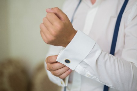 close up of a hand man how wears white shirt with blue suspender and cufflinkの写真素材