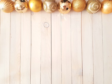 Top view of Christmas holiday background with white vintage wooden deck table over festive christmas gold balls. New Year concept, flat layの写真素材