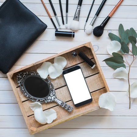 Cosmetic set on light wooden table with mobile, top view, flat layの写真素材