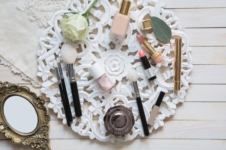 Cosmetic makeup set on light dressing table with mirror, top view, flat layの写真素材