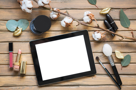 Cosmetic set on vintage wooden table with tablet, top view, flat layの写真素材