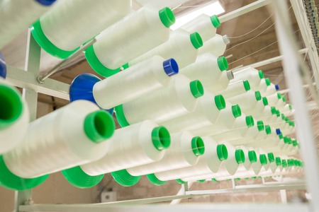 Spun yarns in industrial sewing machine. Factory on manufacture of threads for Industrial Embroidery Machineの写真素材