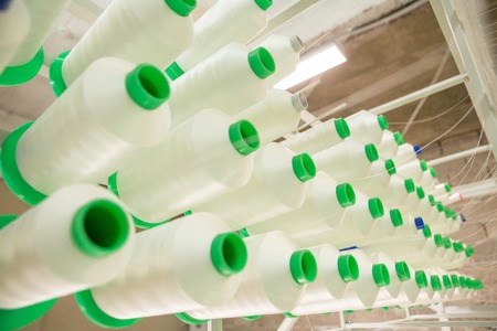 Spun yarns in industrial sewing machine. Factory on manufacture of threads for Industrial Embroidery Machineの写真素材