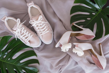 Bridal wedding shoes and sneakers, Accessories, invitations and flowers for the ceremony on the tableの写真素材