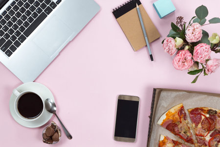 Top view and flat lay with laptop, pizza, coffee and flowers on office table, businesswoman...