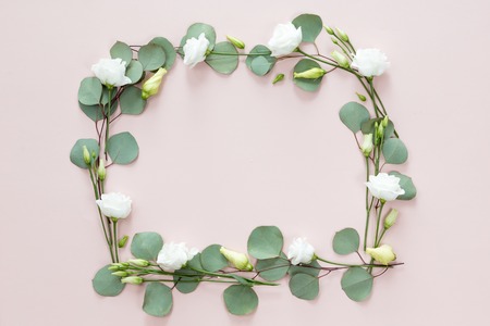 FLower frame with fresh branches, white roses and eucalyptus leaves isolated on white background, flat lay and top view, copy spaceの写真素材