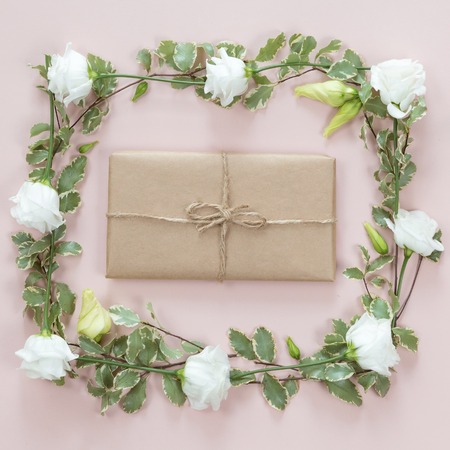 Flowers composition with gift on white pink background. Flat lay, top view.の写真素材