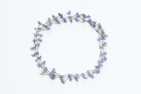 Top view of round flower frame with violet flowers and copy space isolated on white background, flat lay. Greeting card conceptの写真素材