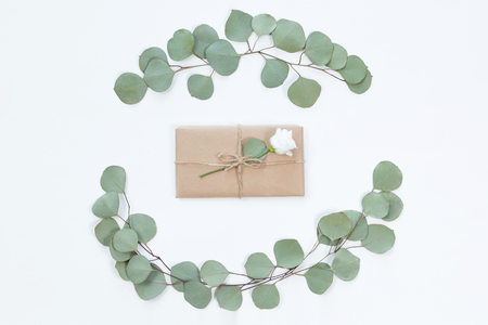 Top view of vintage kraft gift box with flower frame on light desk, flat lay. Greeting card for holidayの写真素材