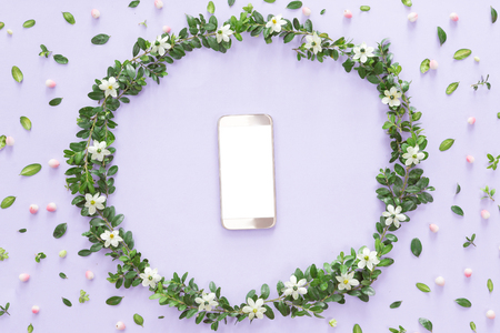 Flower arrangement or composition with a mobile phone in a floral frame, view from above, flat layの写真素材