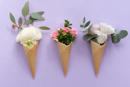 View from above of waffle cone with flower composition on lilac background with copy space, flat layの写真素材