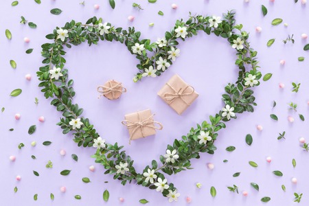 Flat lay of vintage gift box of Kraft eco paper with flower frame wreath on pink background, top view with copy spaceの写真素材