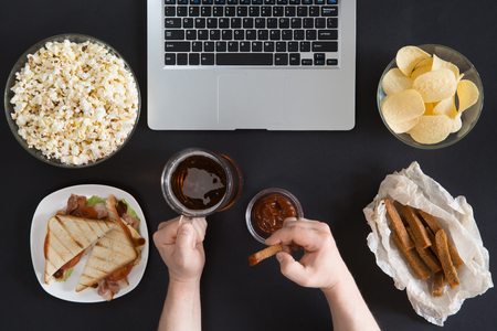 Top view of Snacks and unhealthy food with laptop on black background, gamer conceptの写真素材