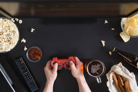 Top view of Snacks and unhealthy food with laptop on black background, gamer conceptの写真素材