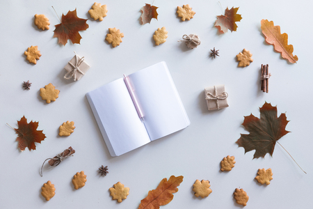 Flat lay, top view of vintage autumn woman office table desk. Workspace with laptop, maple leaves and flowers, diary on white background. Online shopping conceptの写真素材