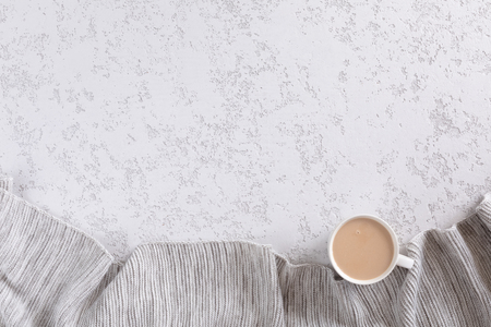 Cup of coffee with milk on white textured background with warm gray plaid, copy space. Flat lay, top viewの写真素材