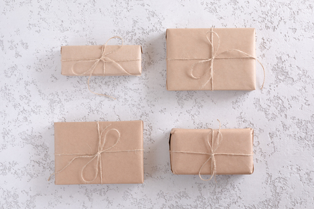 Brown kraft gift boxes on white textured table, top view and flat layの写真素材