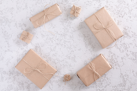 Top view of gift or present boxes wrapped in kraft paper on gray texture table, flat lay, copy spaceの写真素材