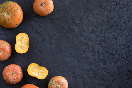 Autumn frame, pumpkins patterned on dark black textured background, top view and flat layの写真素材