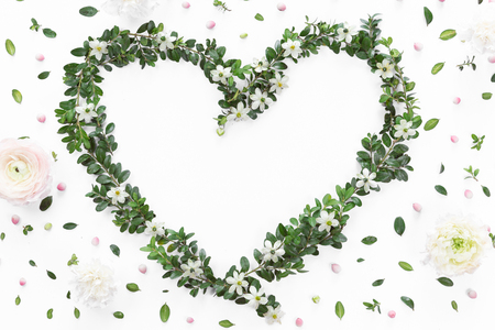 Top view of heart symbol made of natural flowers, buds and leaves. Love concept, flat lay.の写真素材