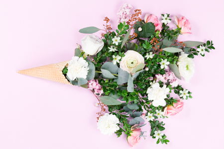 Top view of waffle cone with flowers bouquet on lilac or violet background, flat layの写真素材