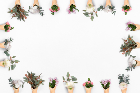 Top view of pattern frame with many waffle cone with flowers on white background, flat lay composition with copyspaceの写真素材