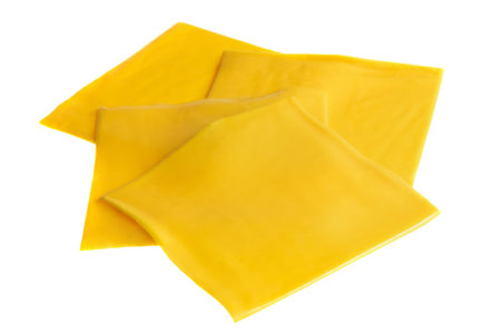 Cheddar cheese slices for burgers isolated on white background.