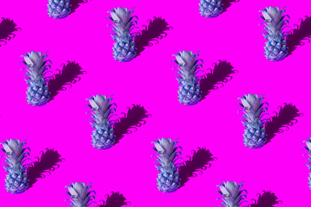 Neon pineapple fruits pattern on pink and blue background. Summer conceptの写真素材