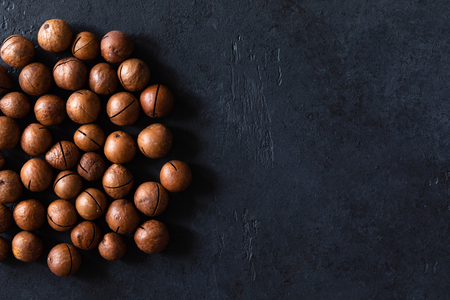 Top view of background texture of fresh natural unshelled raw macadamia nuts, full frame and flat layの写真素材