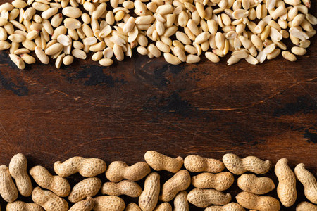 Top view of raw peanuts in shell and peeled as frame texture on wooden background.