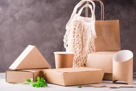 Catering and street fast food paper cups, plates and containers. Eco-friendly food packaging and cotton eco bags on gray background with copy space. Carering of nature and recycling concept.の写真素材