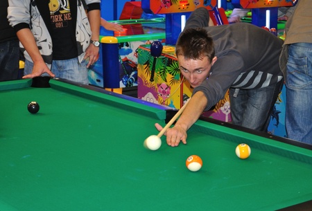 Warsaw, Poland - October 14, 2010 - visitor playing billiard, during SUREXPO 2010 - Salon of Entertainment Devices.のeditorial素材