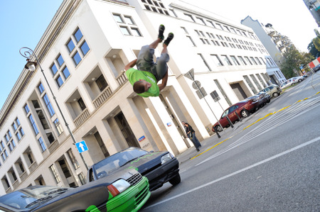 Warsaw, Poland - September 17, 2011:  Parkour acrobat jumping over the cars at the street of Warsaw.のeditorial素材